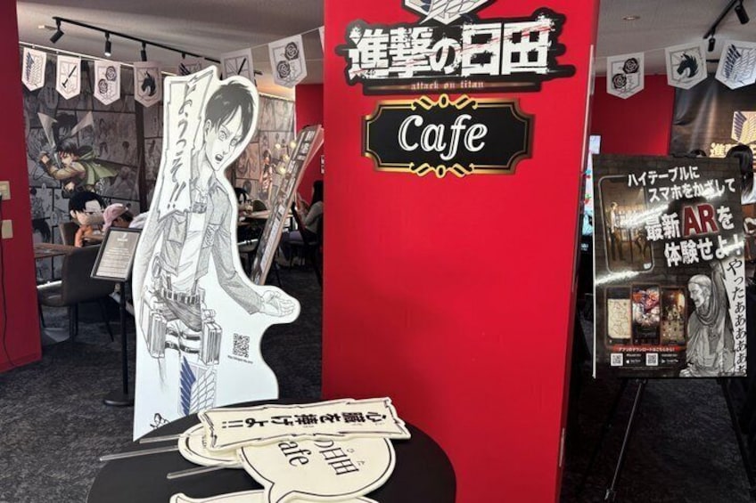 A cafe with a red interior, a black and white poster of a character, and a sign with Japanese text. 5