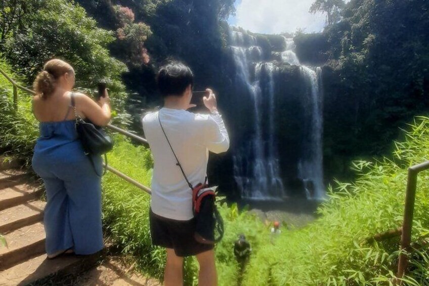 Two people taking photographs of a waterfall. 5
