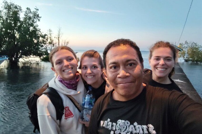 A group of people on a boat with water and trees in the background. 4