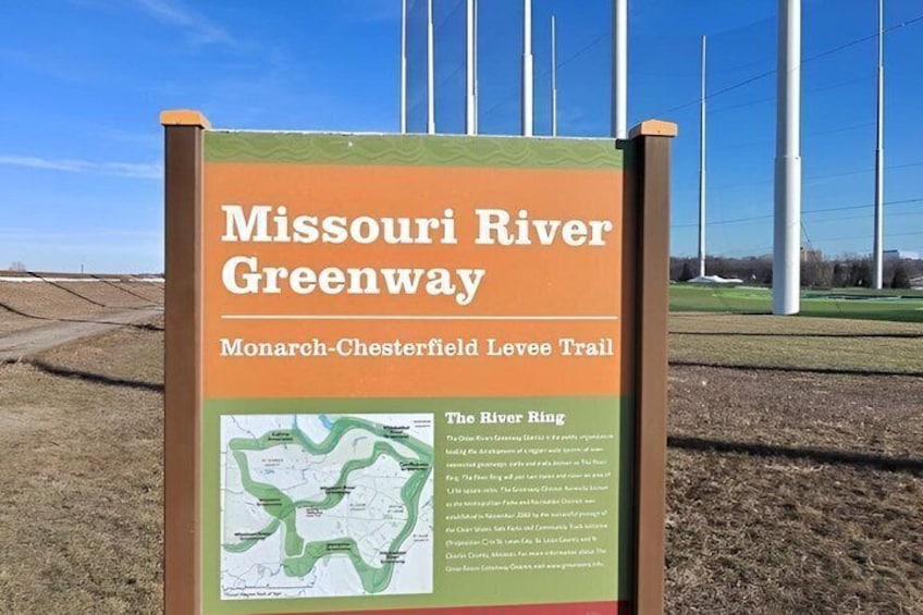 A sign for Missouri River Greenway with a map and text about the Monarch-Chesterfield Levee Trail. 1