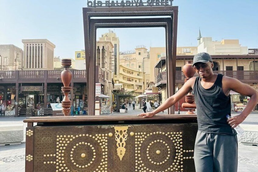 A person standing in front of a decorative metal structure with a cityscape in the background. 2