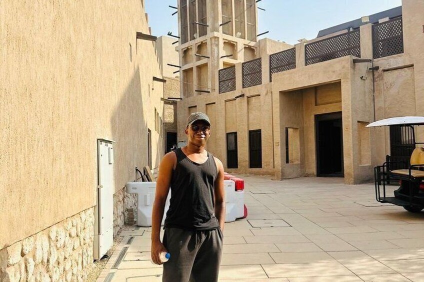A person standing in an outdoor courtyard with a building in the background. 5