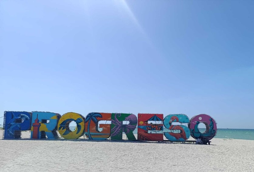 Colorful letters spelling 'PROGRESO' on a beach with the ocean in the background. 4