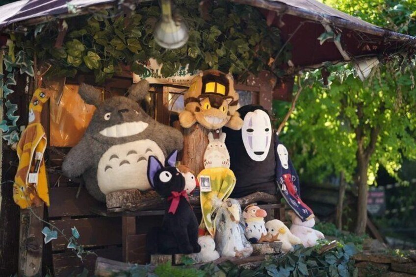 A display of various animated character plush toys, including a large gray creature and several others with different designs. 5