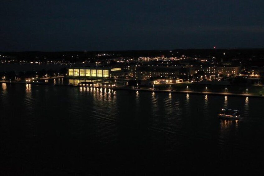 A nighttime cityscape with illuminated buildings reflecting on the water. 2