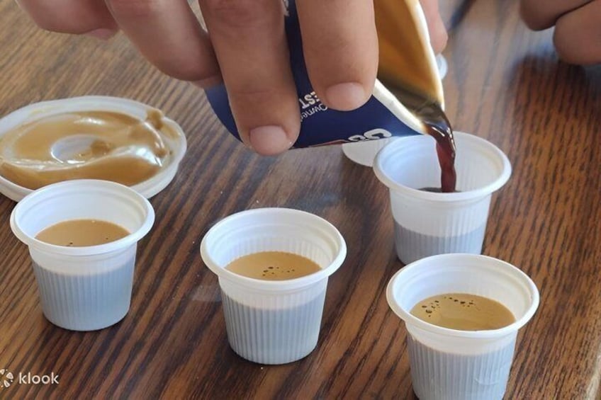 A hand pouring a dark liquid into a cup. 4