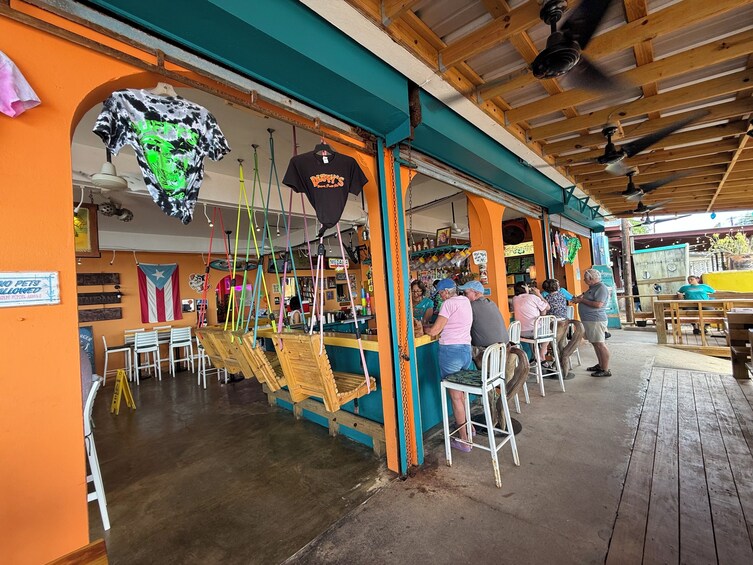A restaurant with outdoor seating, wooden tables, and chairs. 3