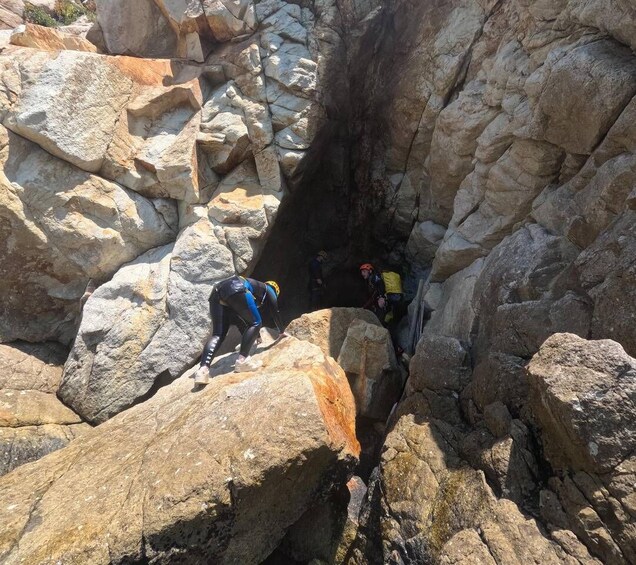 A group of people climbing a rocky cliff. 5