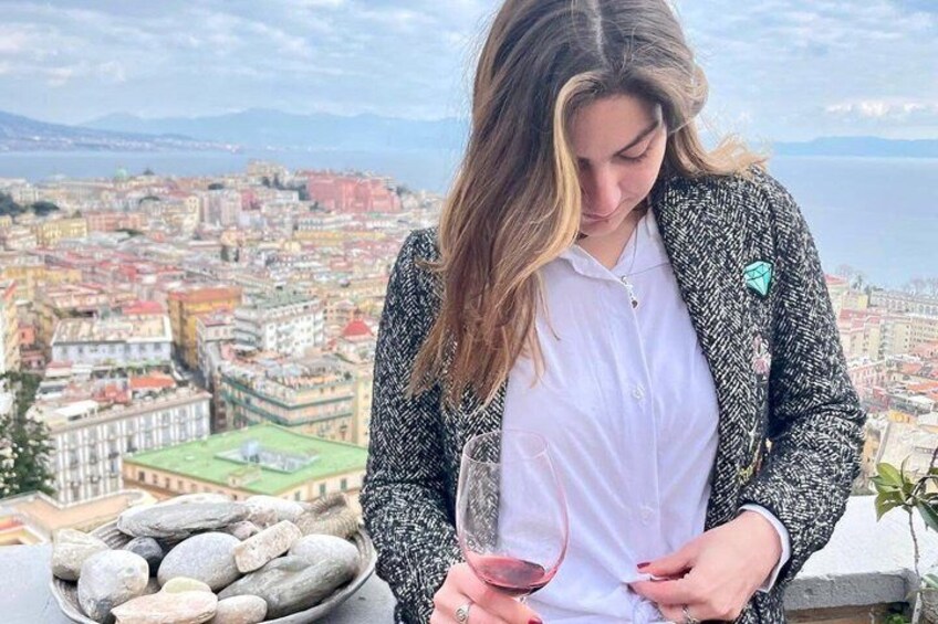 A person holding a wine glass with a cityscape in the background. 2