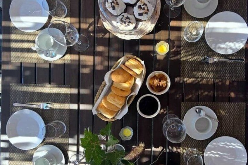 A table set for breakfast with bread, eggs, and beverages. 2