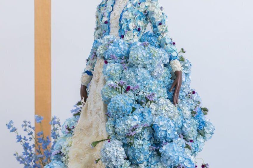 A mannequin wearing a dress covered in blue flowers. 3