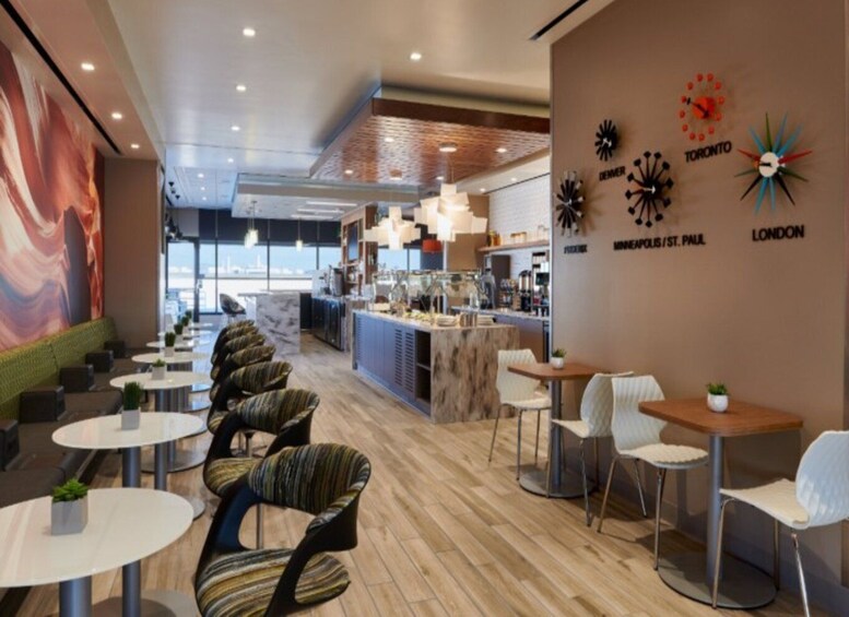 A modern cafe interior with round tables, striped chairs, and a bar area. 4