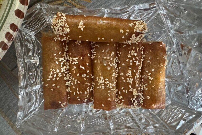 A plastic bag containing several golden-brown pastries sprinkled with sesame seeds. 2