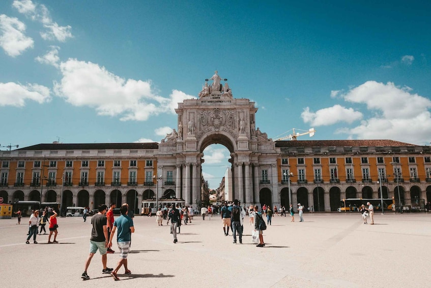 A large open square with an ornate archway in the center, surrounded by historic buildings. 3