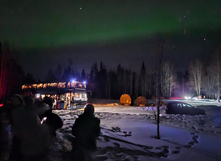 A snow-covered landscape with a lit building and two illuminated spherical objects. 4