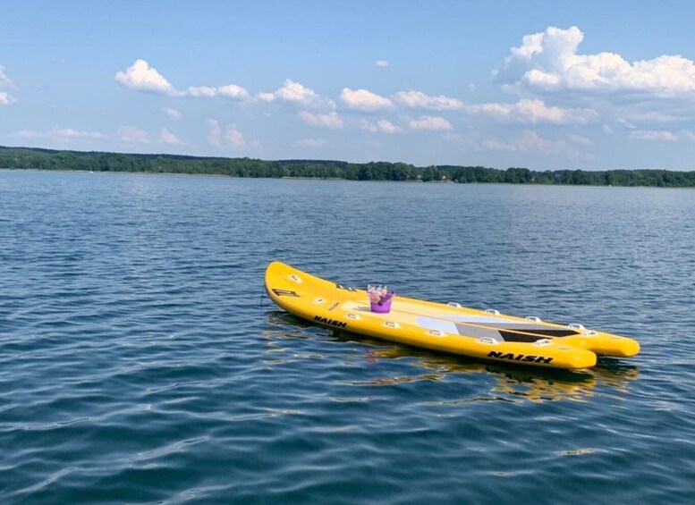A yellow inflatable raft on calm water with a clear sky and distant trees. 1