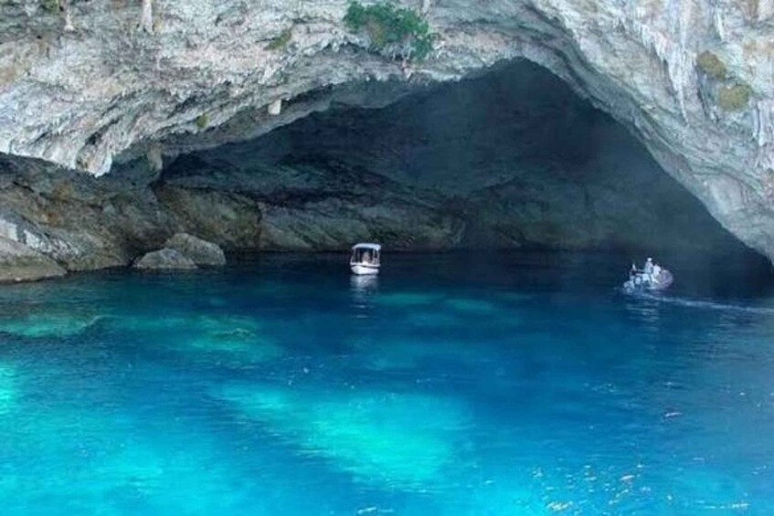 A boat in a clear blue cave pool with rocky walls. 2