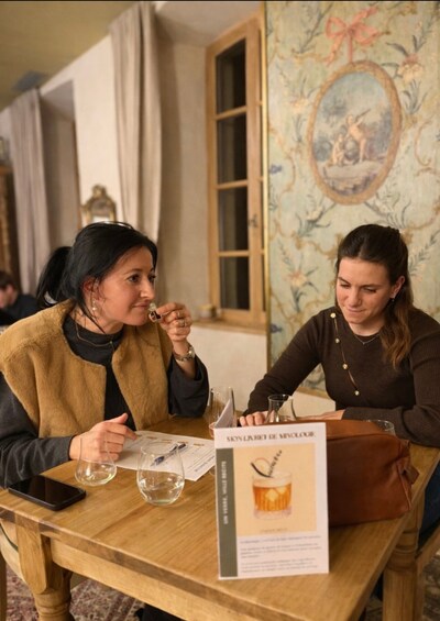 Two people sitting at a wooden table with a menu and a glass of water. 5