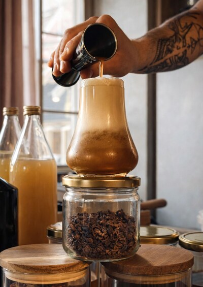 A person pouring a liquid into a glass container. 5