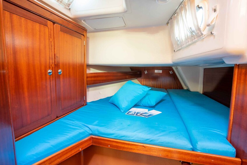 A compact cabin with a bunk bed, wooden cabinetry, and a small window. 2