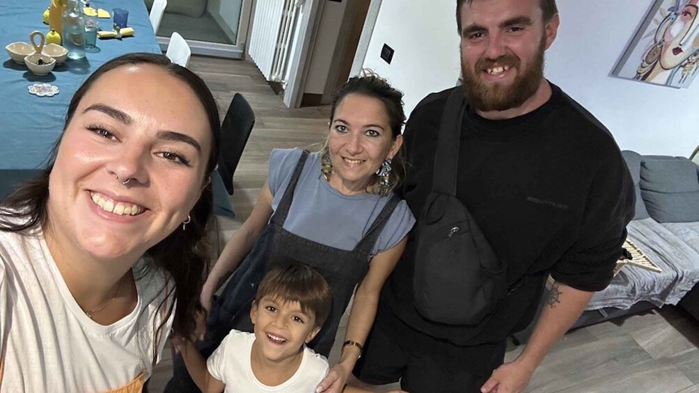 A family of four in a modern living room with a blue sofa, a coffee table with decorative items, and a door in the background. 5