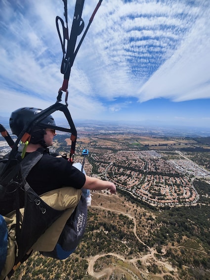 A person in a harness and helmet, overlooking a cityscape from a high vantage point. 2