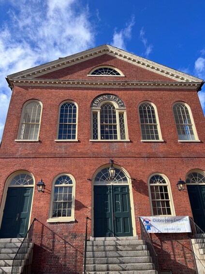 A red brick building with arched windows and a town hall sign. 4