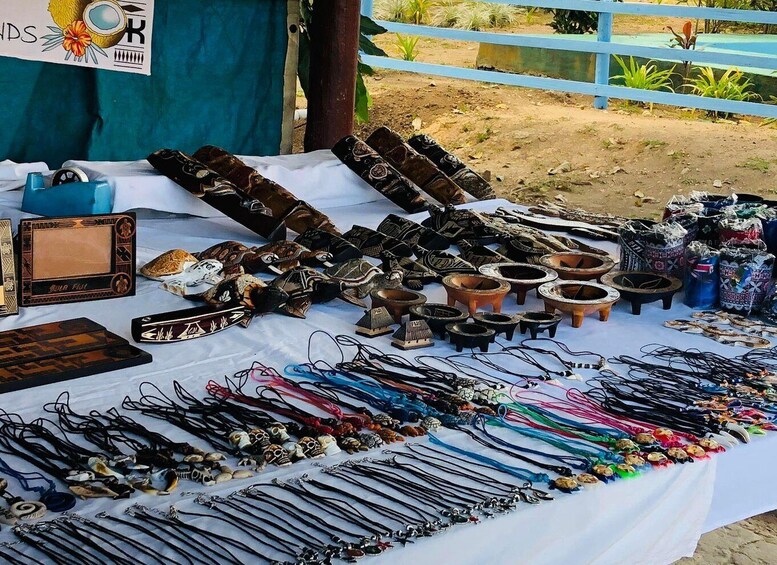 A variety of handcrafted items displayed on a table, including pottery, jewelry, and decorative objects. 5