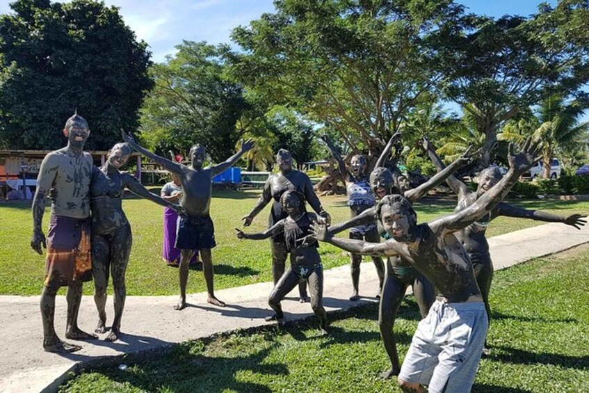 A group of people in a park with trees and a clear sky. 1