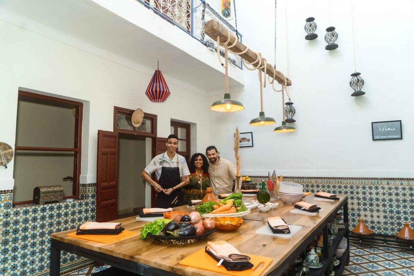 A kitchen with a long wooden table, hanging lights, and a tiled backsplash. 4