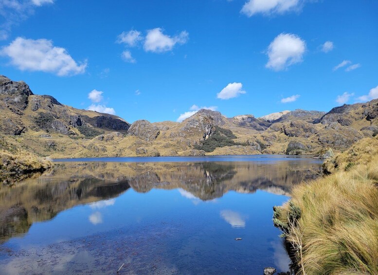 Ein ruhiger See, umgeben von zerklüfteten Bergen unter blauem Himmel. 4