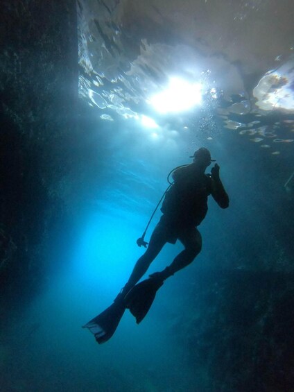 A diver descending into a blue underwater environment with bubbles and light reflections. 4