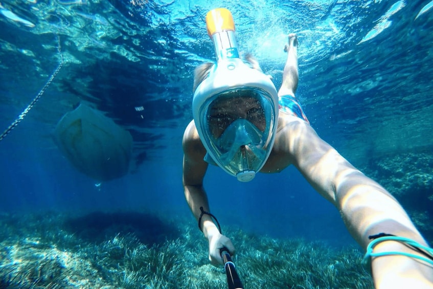 A person snorkeling underwater with a snorkel and mask. 3