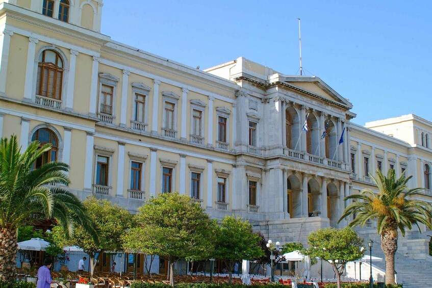 A classical building with columns and a flagpole. 2