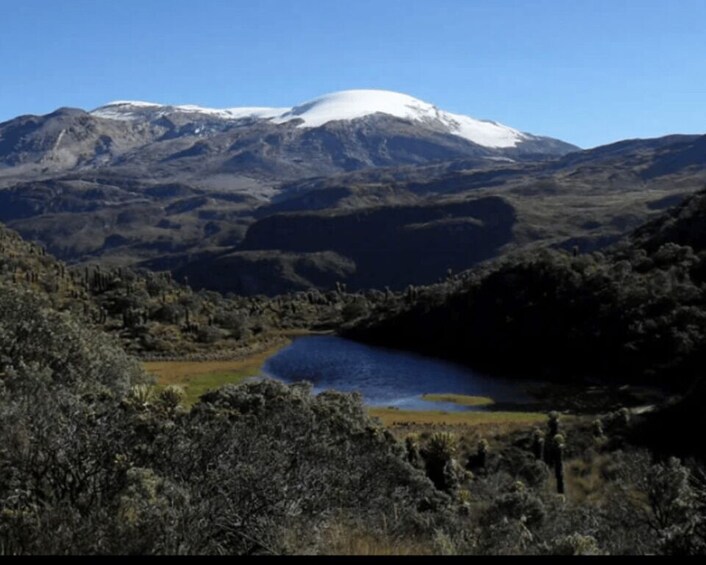 A snow-capped mountain, a lake, and a forested valley. 2