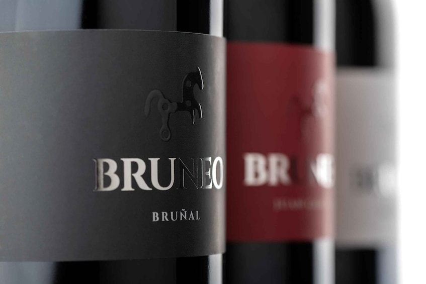 A row of wine bottles with labels. 4