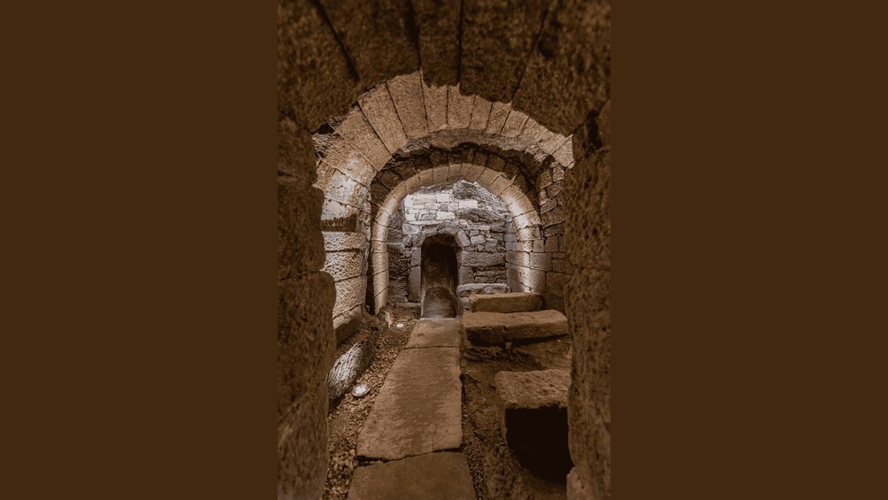 An ancient stone archway leading into a narrow passageway. 2