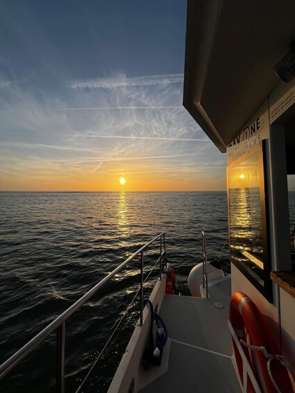 A boat at sunset with the sun reflecting on the water. 2