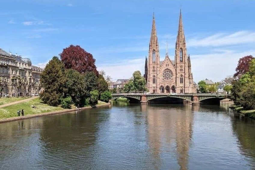 A cathedral with two spires, a river, and trees. 3
