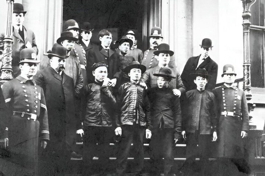A group of men in military uniforms standing in front of a building with columns. 1