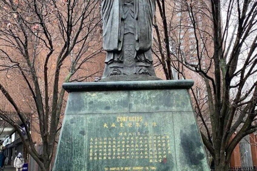 A statue of Confucius on a pedestal with inscriptions. 2