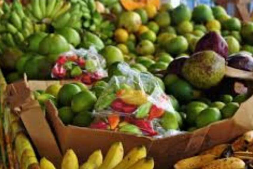 A variety of fruits including bananas, avocados, and green apples in a market setting. 3