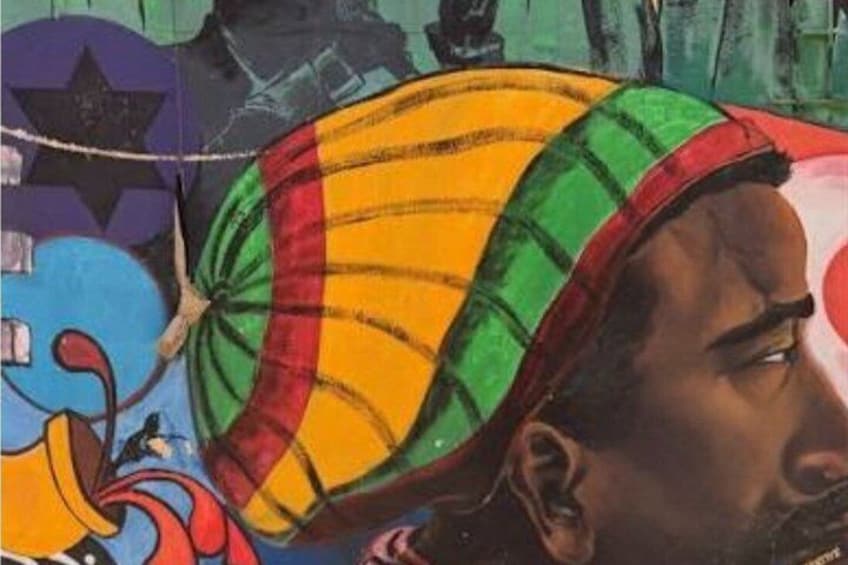 A colorful mural with a person wearing a striped hat. 1
