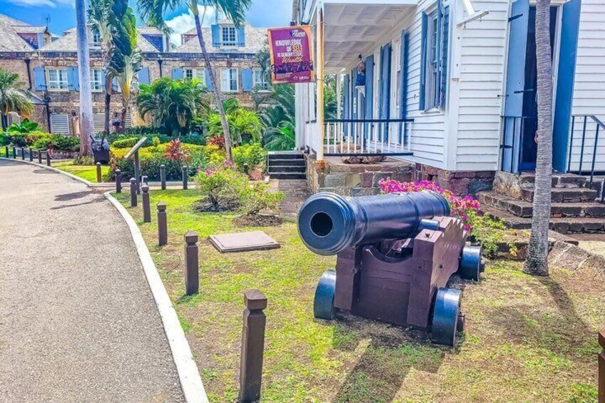 A cannon in a grassy area with a building in the background. 4