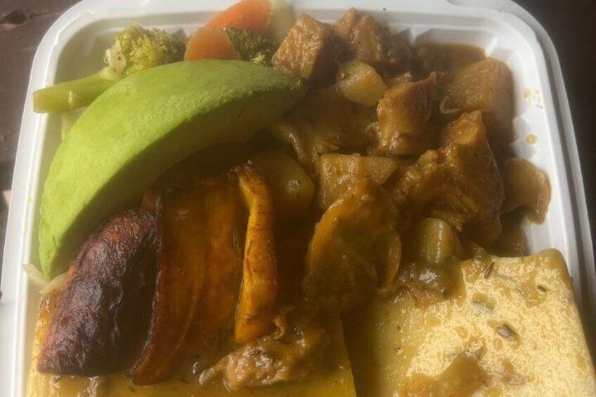 A meal with meat, vegetables, and a slice of avocado in a container. 3