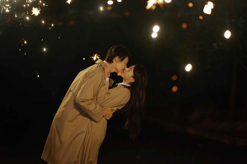 A couple embracing under a night sky with visible stars and bokeh lights. 1