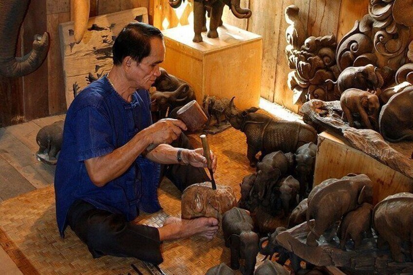 A person carving a wooden sculpture of an animal. 1