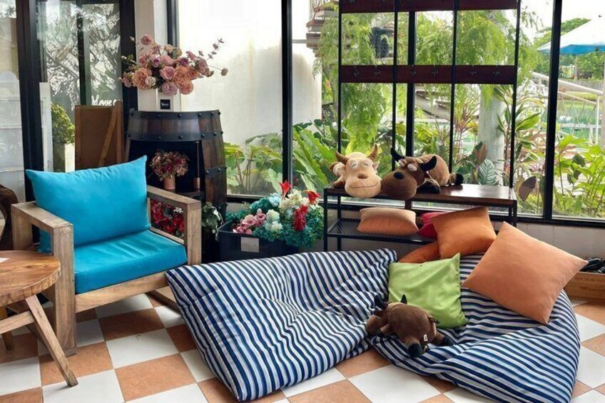 A cozy indoor seating area with a blue chair, striped cushions, and a wooden table. 4