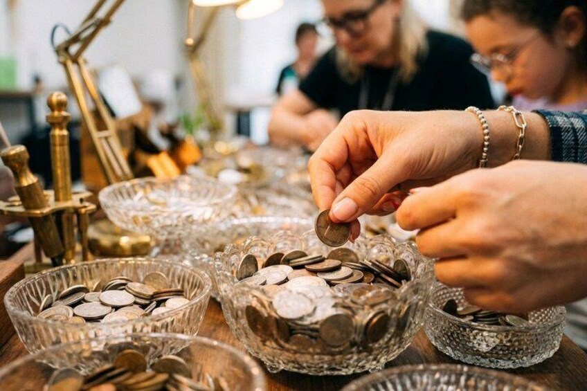 Hands placing coins into glass bowls. 1