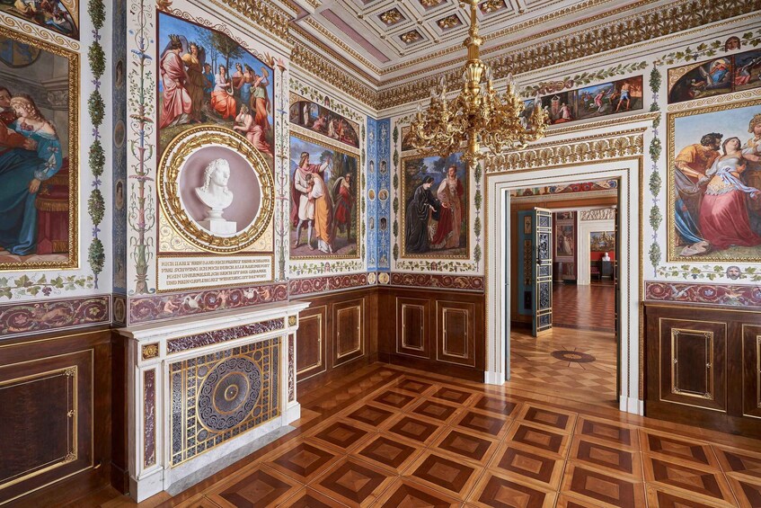 An ornate room with elaborate frescoes, a large chandelier, and classical architectural details. 3